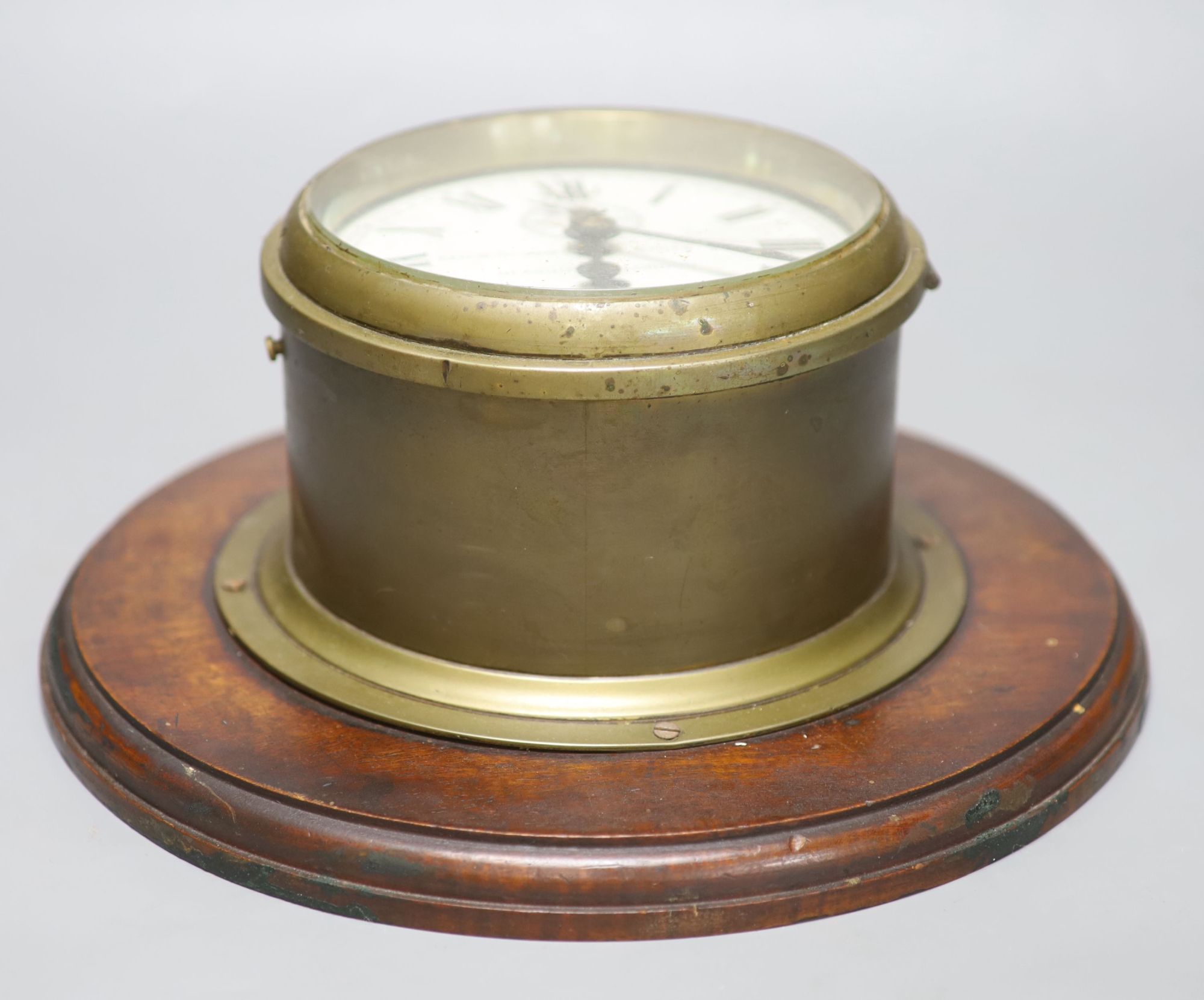 Kenneth James White Ltd., Glasgow and London. A brass cased bulkhead timepiece, mahogany mounted